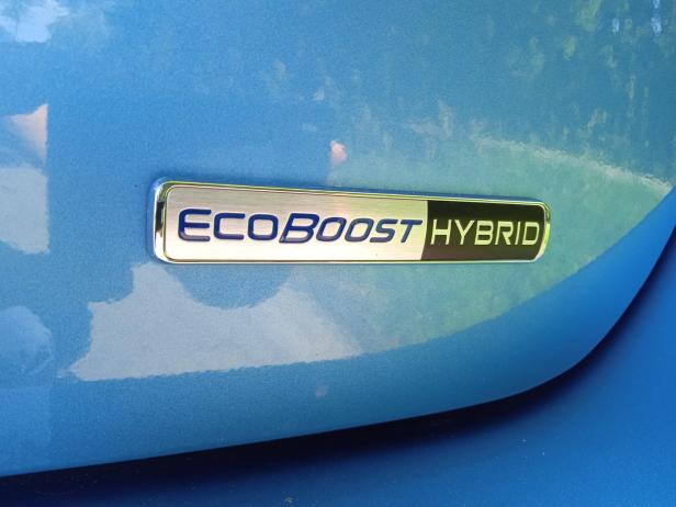 Das „EcoBoost Hybrid“-Emblem auf einem blauen Auto.