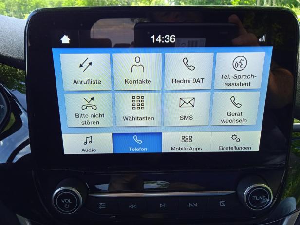 Das Display eines Autos zeigt Menüoptionen wie Anrufliste, Kontakte und Telefoneinstellungen.