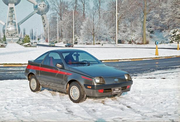 Ein grauer Ford Ghia Shuttler steht im Schnee vor dem Atomium in Brüssel.