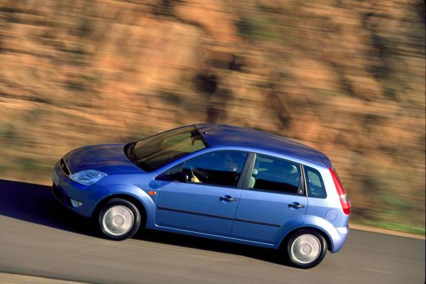 Ein blauer Ford Fiesta fährt auf einer Landstraße.