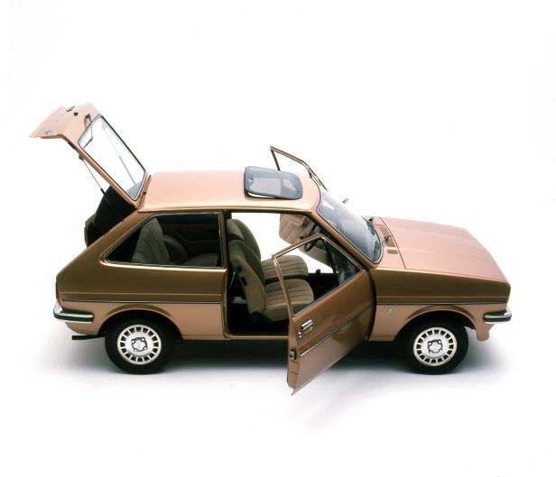 Ein goldfarbener Ford Fiesta 1.1 Ghia von 1976 mit geöffneten Türen und Heckklappe.