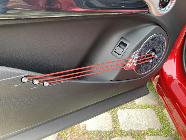 Die Türverkleidung eines Autos mit einem roten, gitarrenähnlichen Design.