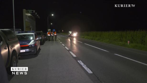 Eine Polizeikontrolle findet nachts auf einer Landstraße statt.