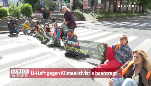 Klimaaktivisten blockieren eine Straße mit einem Banner gegen neue Bohrungen.