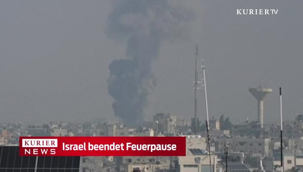 Über einer Stadt steigt eine dunkle Rauchsäule auf.