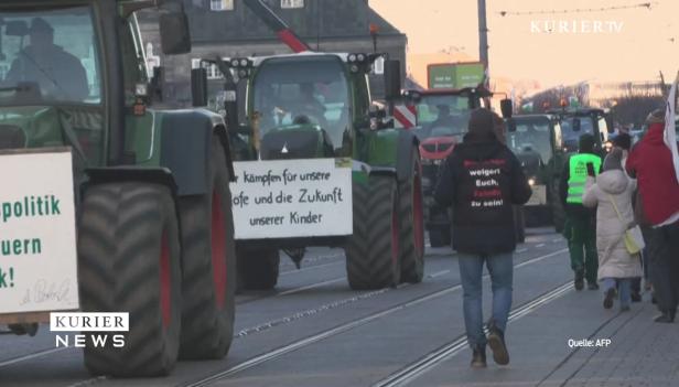 Eine Demonstration von Landwirten mit Traktoren und Protestschildern in einer Stadt.