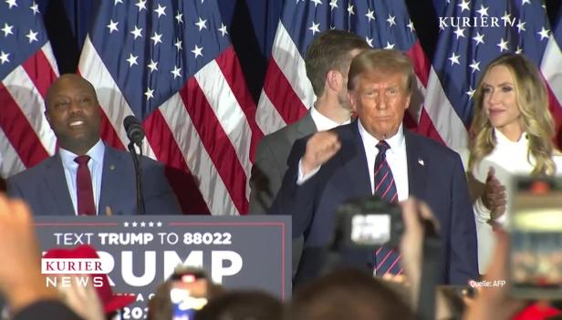 Donald Trump bei einer Rede vor amerikanischen Flaggen.