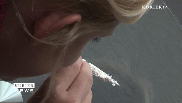 Eine Frau beugt sich über eine Linie weißen Pulvers.