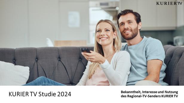 Ein Paar sitzt auf einem Sofa und schaut fern.