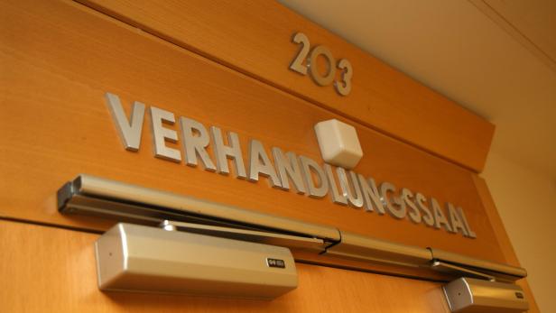 Die Tür zum Verhandlungssaal 203 ist mit einem Türschließer versehen.