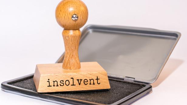 Ein Stempel mit dem Wort „insolvent“ liegt auf einem Stempelkissen.