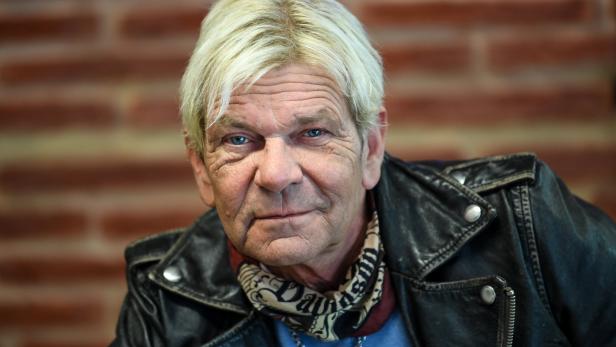 Matthias Reim mit Lederjacke vor einer Backsteinwand.
