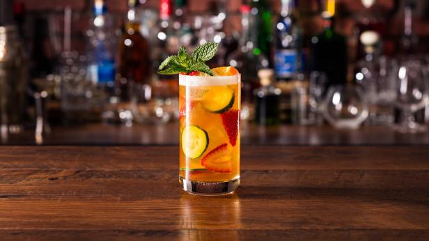 Ein Glas mit einem alkoholfreien Getränk, dekoriert mit Erdbeeren, Gurken und Minze.