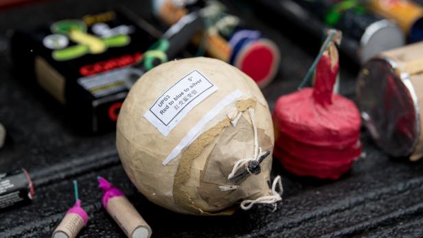 Verschiedene Feuerwerkskörper liegen auf einer dunklen Oberfläche.