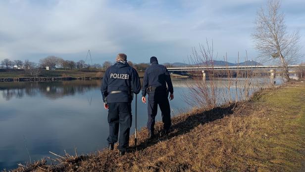 Zwei Polizisten am Ufer der Donau.
