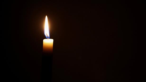 Kerze leuchtet im Dunkeln.
