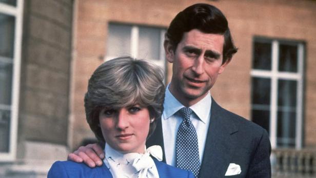 Prinz Charles und Prinzessin Diana stehen gemeinsam vor einem Gebäude.