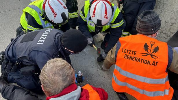 Einsatzkräfte versuchen, Aktivisten der „Letzten Generation“ von der Straße zu lösen.