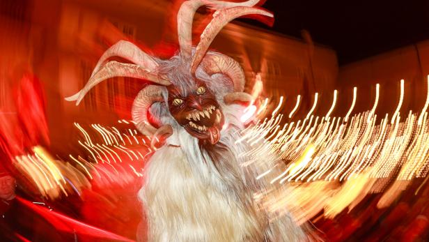 Ein Krampus mit Fell, Hörnern und einer furchteinflößenden Maske bei einem Umzug.