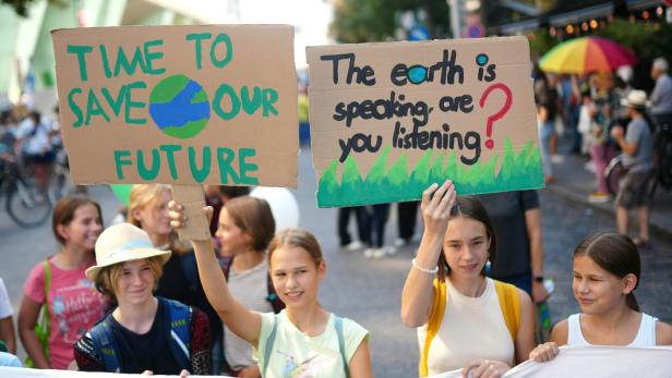 Eine Gruppe junger Menschen demonstriert mit Schildern für den Klimaschutz.