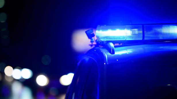 Blaulicht leuchtet auf dem Dach eines Einsatzfahrzeugs in der Dunkelheit.