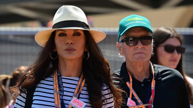 Catherine Zeta-Jones und Michael Douglas tragen Hüte und Sonnenbrillen im Freien.