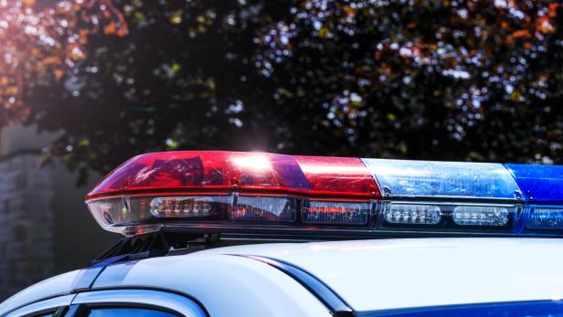 Blaulicht und rotes Licht auf dem Dach eines Polizeiautos.