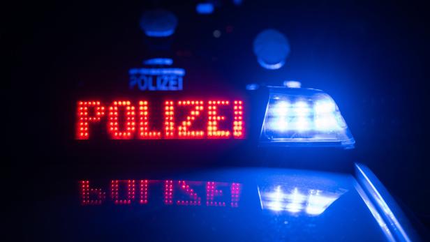 Polizeischriftzug auf Polizeiauto bei Nacht.