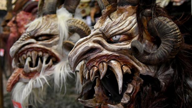 Nahaufnahme von Krampusmasken mit Hörnern und spitzen Zähnen.