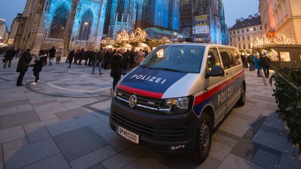 Ein Polizeiwagen steht vor dem beleuchteten Stephansdom in Wien.