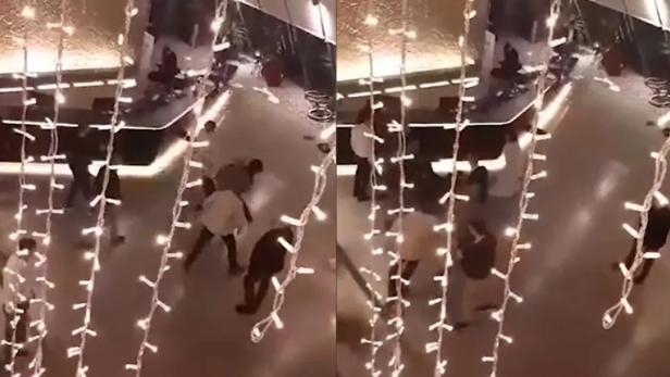 Menschen stehen und gehen unter einer Lichterkette.