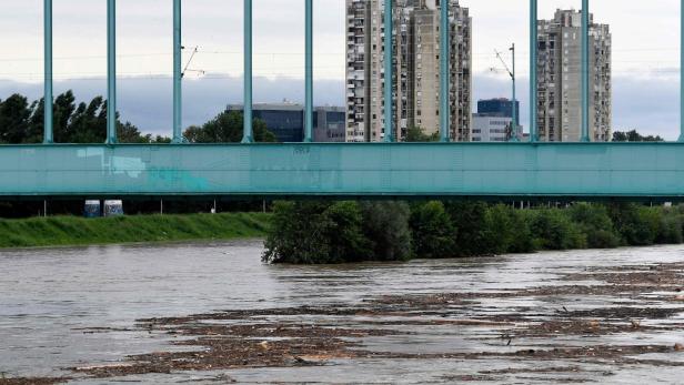 Hochwasser unter einer Brücke in Kroatien, mit Trümmern im Fluss.