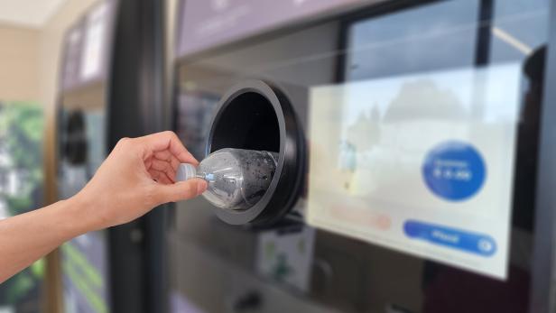 Bringing used water bottles to recycle at vending machines reduces waste and pollution problems and protects the environment. Blurred background.