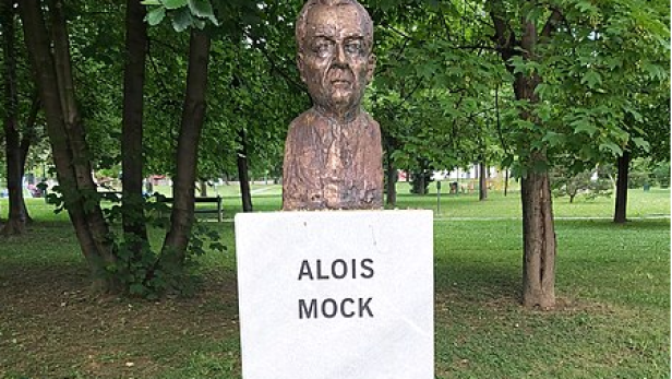 Eine Bronzebüste von Alois Mock in einem Park.