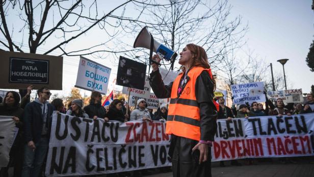 Eine Frau spricht bei einer Demonstration in Serbien durch ein Megaphon.