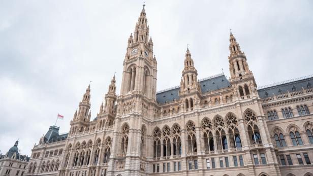 Das Wiener Rathaus mit seinem markanten Turm und der österreichischen Flagge im Wind.