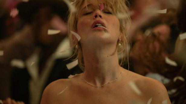 Eine Frau steht inmitten einer Konfettiregen auf einer Party.