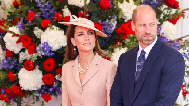Prinz William und Prinzessin Kate vor einer Blumenwand