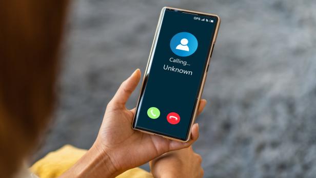 Frau hält Handy mit einkommenden Anruf in der Hand