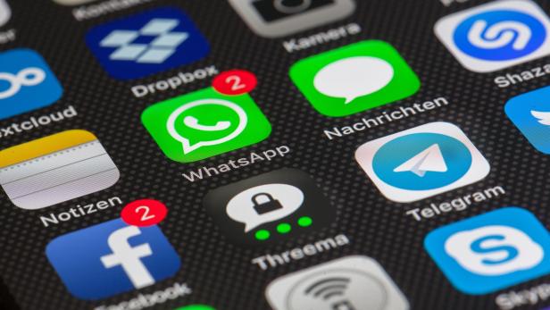 Mehrere bekannte App-Symbole wie WhatsApp, Facebook, Telegram und Dropbox sind auf einem Smartphone-Display zu sehen.