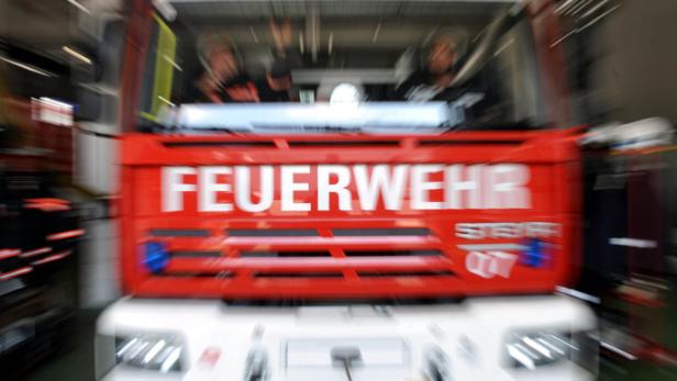 Ein rotes Feuerwehrfahrzeug mit der Aufschrift "FEUERWEHR" ist zu sehen.