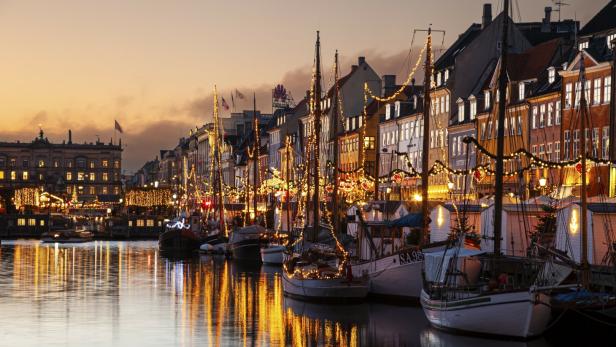Den Nyhavn von Kopenhagen bei Nacht mit vielen Lichtern 