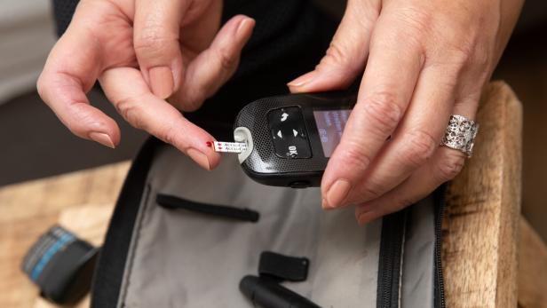 Eine Frau misst ihren Blutzuckerspiegel.