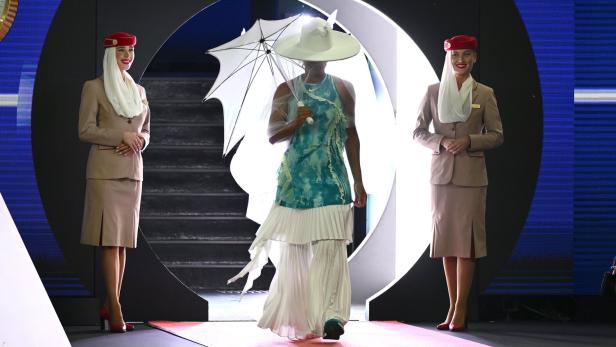 Naomi Osaka betrifft mit mit Hut und Schirm den Centercourt.