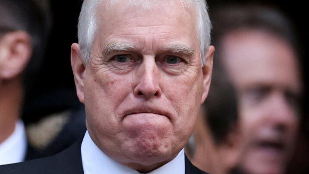 Ex-Prinz Andrew Mountbatten-Windsor trägt einen dunklen Anzug mit Krawatte und blickt ernst.