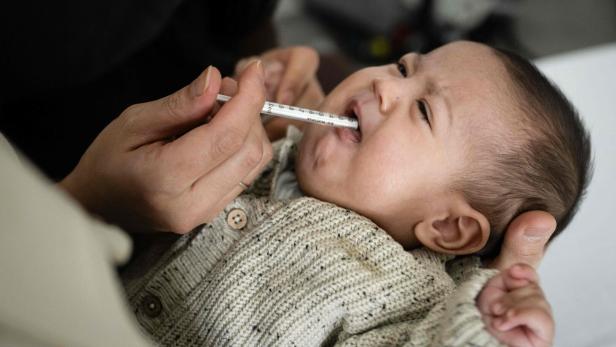 Mutter Viviane gibt ihrem Sohn Issa eine Spritze