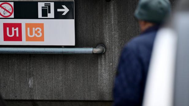 Ein Schild mit den Aufschriften U1 und U3 und einem Pfeil nach rechts hängt an einer grauen Wand.