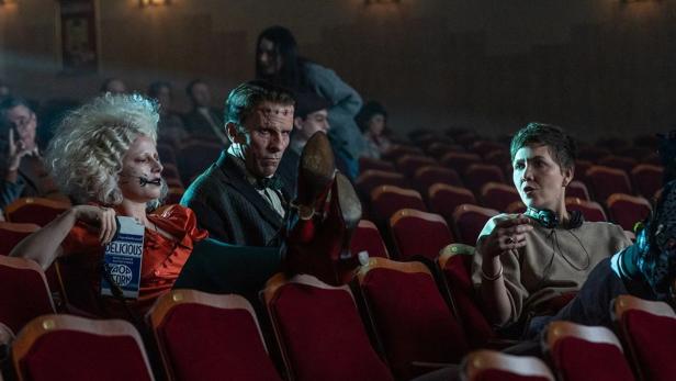 Jessie Buckley und Christian Bale sitzen als Braut und Frankenstein-Monster im KIno