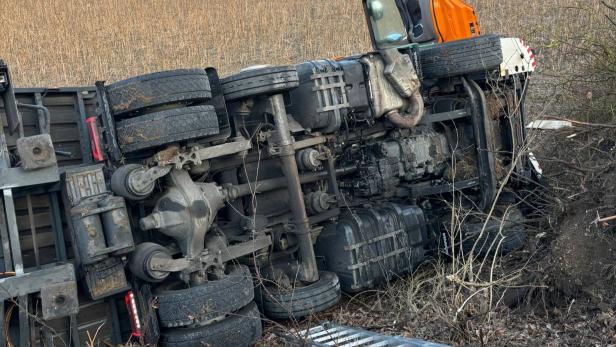 Sattelschlepper liegt umgestürzt in einem Feld