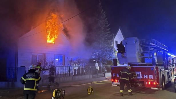 Eine Aufnahme der Feuerwehr vor dem Einfamilienhaus, aus dessen Fenster Flammen schlagen.